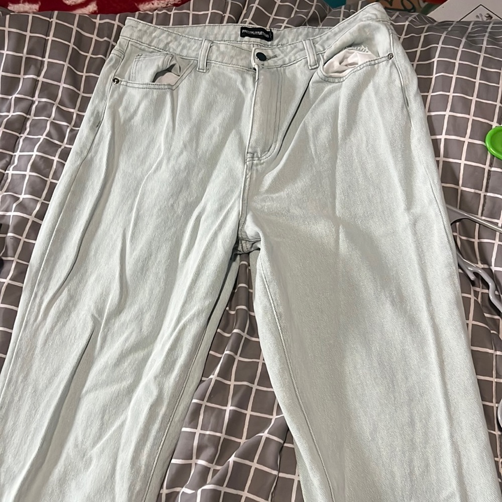 Very pale, light blue denim jeans with a small slit on the bottom